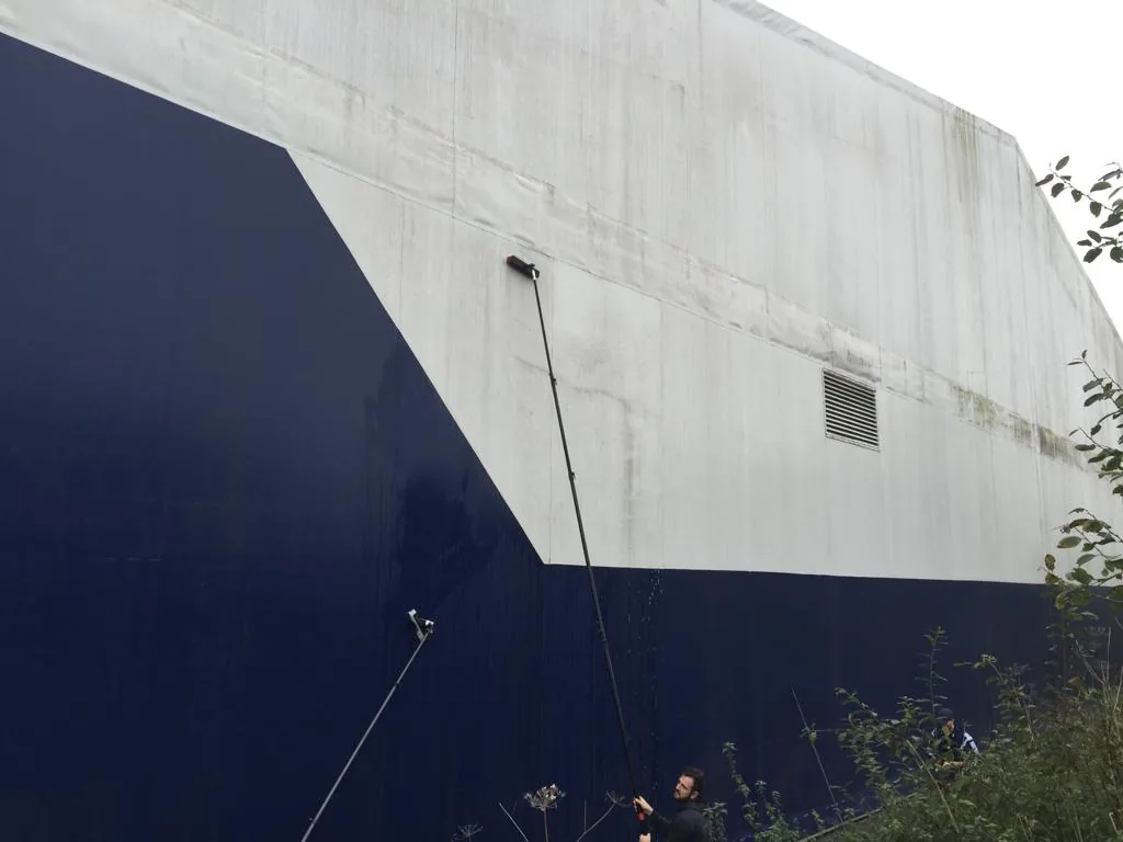 Cladding cleaning technician working from an elevated platform