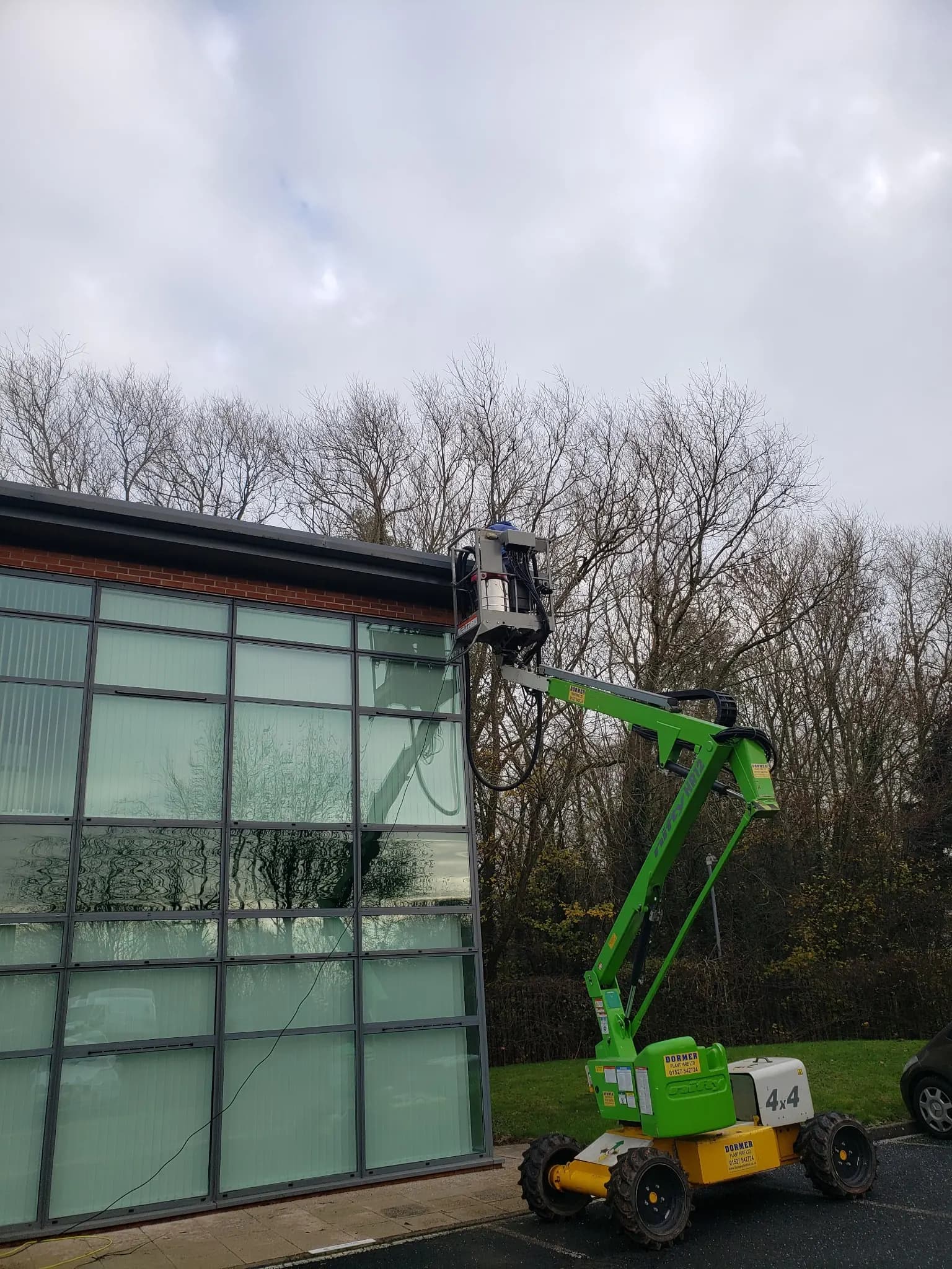 Spider lift access platform cleaning a glazed commercial building facade