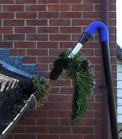 Gutter vacuum removing debris and blockages during a gutter clean