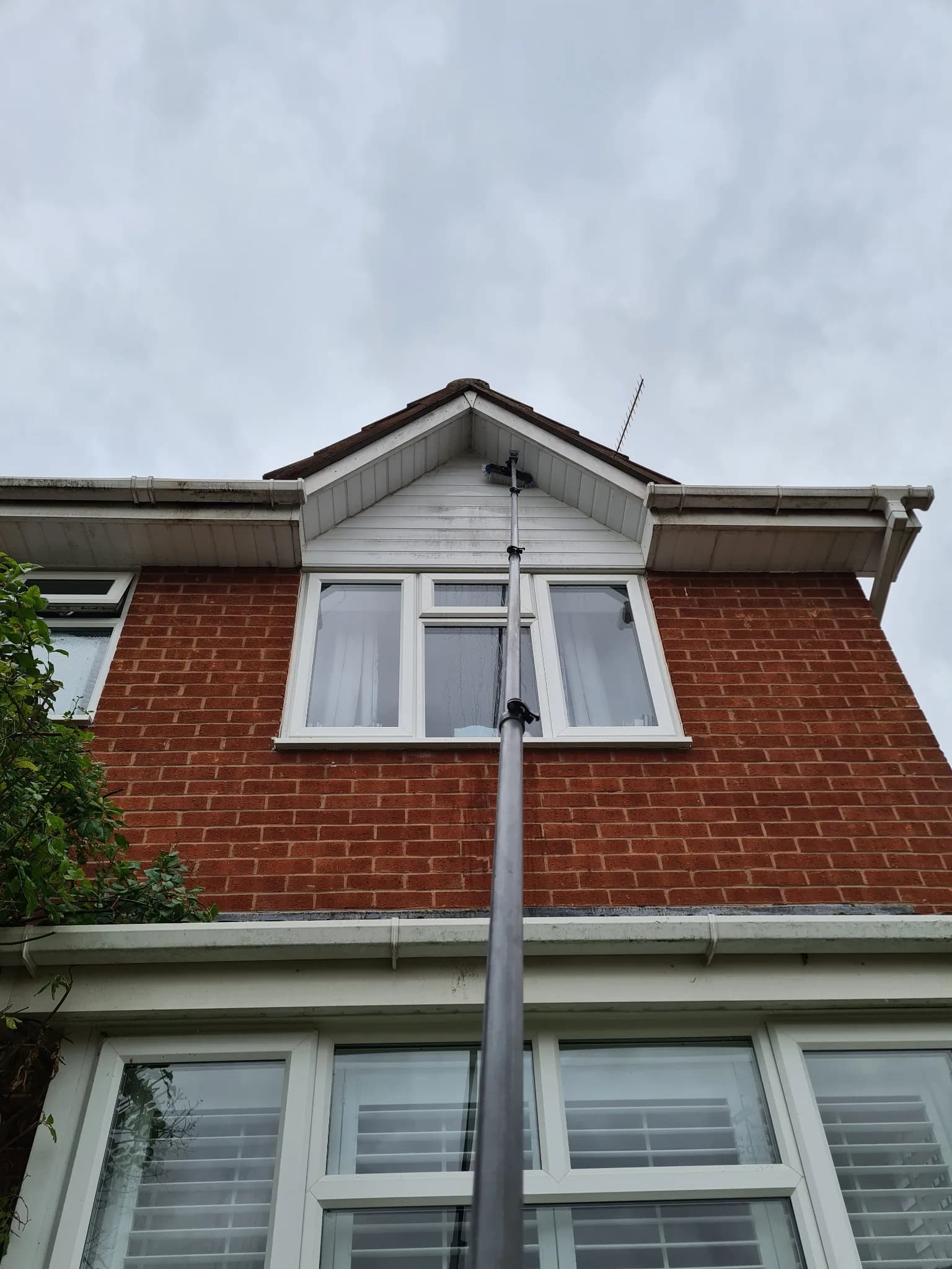 Upper storey residential windows being cleaned with a pure water pole system